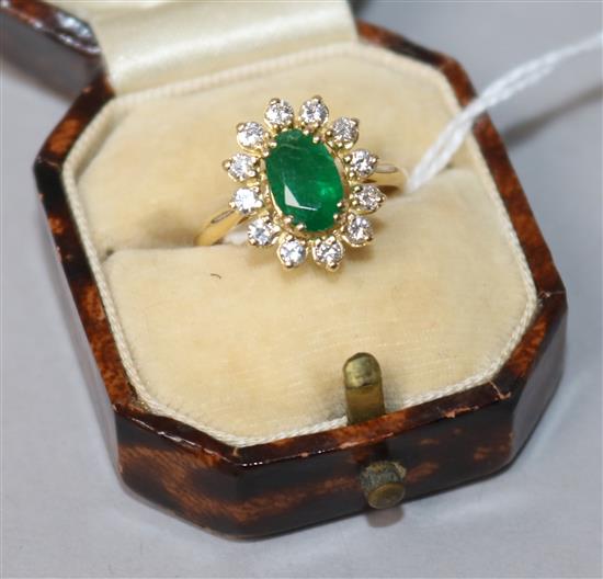 A modern 18ct gold, emerald and diamond oval cluster ring, size M.
